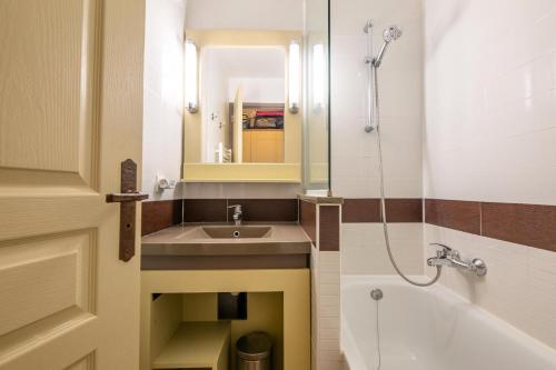 une salle de bain avec un lavabo, un miroir et une baignoire dans l'établissement Résidence le Village de Cap Esterel - maeva Home - Appartement 2 pièces 4 personnes - Sélection MAE-3781, à Saint-Raphaël