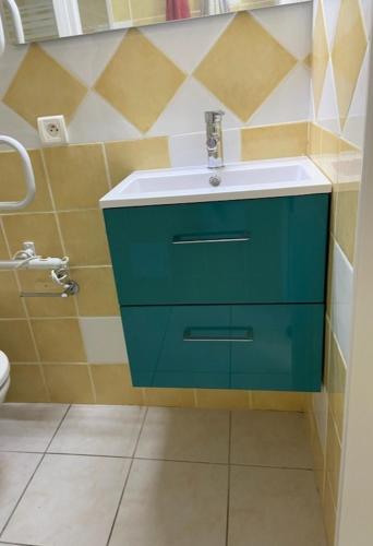 une salle de bain avec un lavabo vert et des toilettes dans l'établissement Appartement T1 bis proche plage, à Bretignolles-sur-Mer