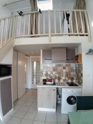 - une cuisine avec un évier et un escalier dans la chambre dans l'établissement Appartement T1 bis proche plage, à Bretignolles-sur-Mer
