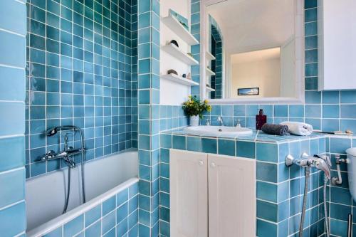 a blue tiled bathroom with a tub and a sink at Les Mas et Villas de Pont Royal en Provence - maeva Home - Villa duplex moderne et vintage 3 pièces 6 personnes climatisée - Prestige - super Home MAE-4211 in Mallemort