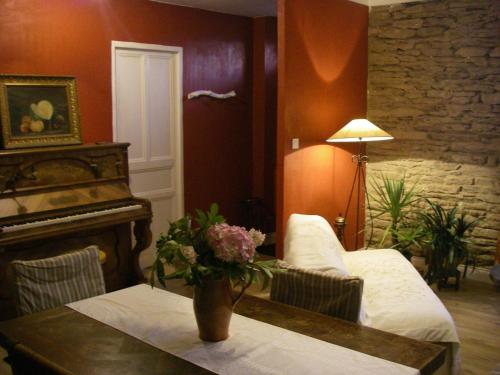 ein Wohnzimmer mit einem Tisch und einem Klavier in der Unterkunft Chambre d'hôtes La Maison du Neuilly in Le Conquet