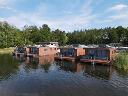 a row of houses sitting on the water at Haus auf dem See Elise, Matheo, Mads, und Jarle in Ferchesar