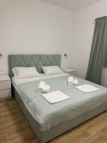 a bedroom with a bed with two towels on it at Seaside PERLA Apartment in Martinšćica