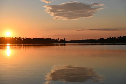 a sunset over a large body of water at Haus auf dem See Elise, Matheo, Mads, und Jarle in Ferchesar
