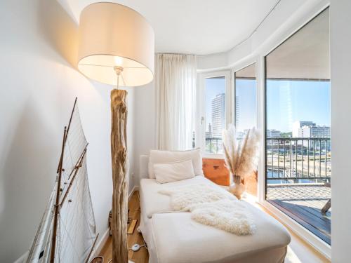 a living room with a white couch and a large window at Maison Beaufort - uniek zicht op de jachthaven in Ostend