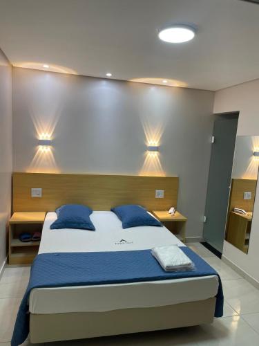 a bedroom with a large bed with blue pillows at Hotel Flert - Tatuapé in Sao Paulo