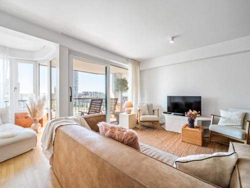 a living room with a couch and a tv at Maison Beaufort - uniek zicht op de jachthaven in Ostend