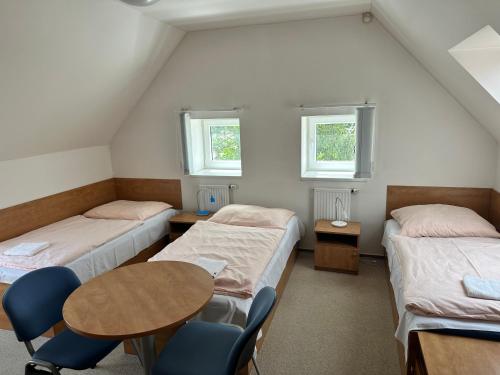 a room with three beds and a table and chairs at Apartmán 4 - ČASPV in Prague