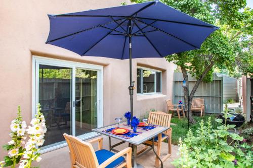 a table with a blue umbrella on a patio at Heart of Vibrant Railyard-Large Downtown Loft with Prime Location and Beautiful Deck in Santa Fe