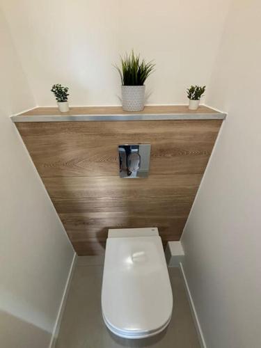 une salle de bain avec toilettes et plantes sur le comptoir dans l'établissement A3 - neuf 2024 - ORLY - PARIS EXPO - 4 chambres, à Antony