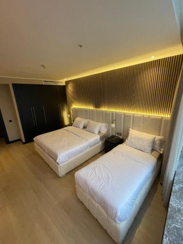 two beds in a hotel room with white sheets at Tanger Hilton Penthouse 15 in Tangier