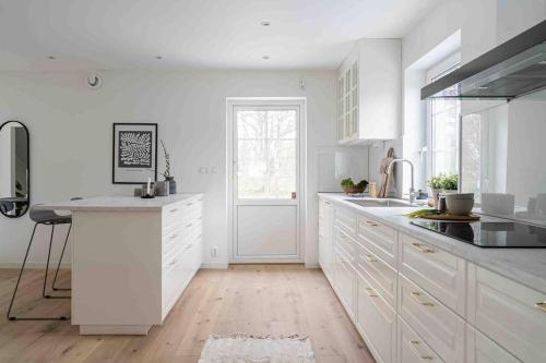 a white kitchen with white cabinets and a sink at The cheerful nordic homes in Perstorp