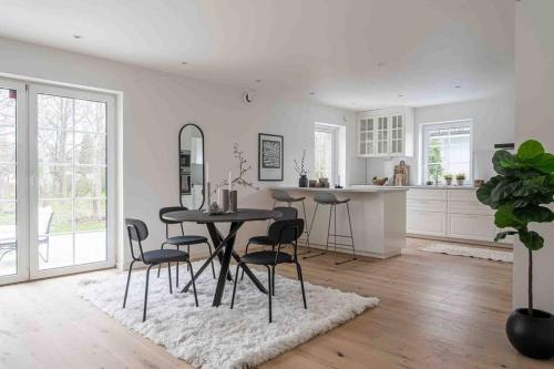 a kitchen and dining room with a table and chairs at The cheerful nordic homes in Perstorp
