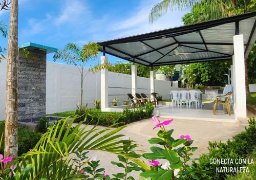 a pavilion with chairs and tables in a garden at Casa villa con Jacuzzi, tobogán y BBQ in Carmen de Apicalá