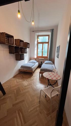a room with two beds and a table at H. Kloss Rooms in Łódź