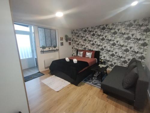 une chambre avec un lit et un canapé dans une pièce dans l'établissement Studio le Trésor d'amour, à Noyers-sur-Cher