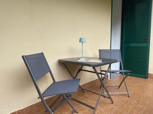 a table with two chairs and a table with a lamp at Acquadolce Apartment in Baveno