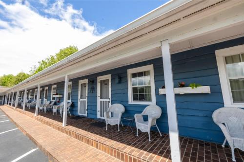 a blue building with white chairs on the porch at Blowing Rock Inn in Blowing Rock