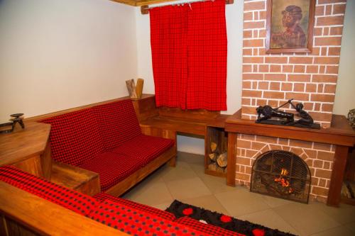 a room with a brick fireplace and a red curtain at Swiss Farm Cottage in Lushoto