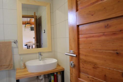 bagno con lavandino e porta in legno di Guest House Krsmanovic a Mokra Gora