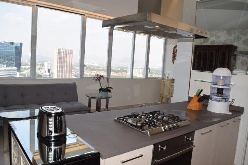 a kitchen with a stove top oven next to a couch at Centro de Convenciones CitiBanamex y Polanco in Mexico City
