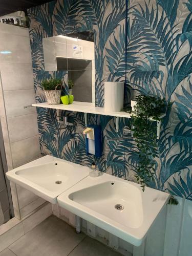 a bathroom with a sink and a blue and white wallpaper at Surf Przyczepa Jastarnia in Jastarnia