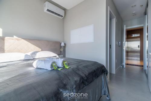 a bedroom with a large bed with white walls at MHFA - Studios em Prédio Luxuoso com Vista Mar in Itapema