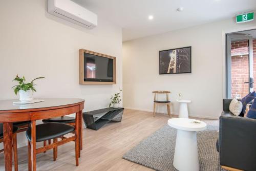 ein Wohnzimmer mit Tisch und Couch in der Unterkunft George Little Stylish, Peaceful & Convenient in Dunedin