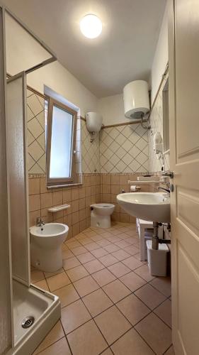 a bathroom with two sinks and a toilet and a window at Amly's Room in Maratea