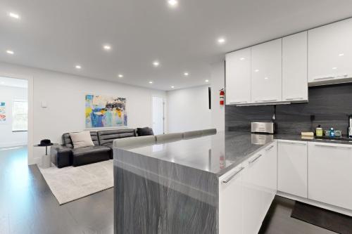 a kitchen with white cabinets and a living room at The 1-Main St in Bar Harbor