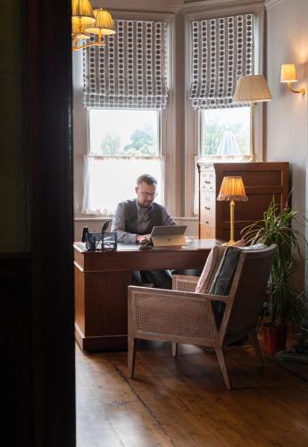 a man sitting at a desk with a laptop at Hotel Victoria in Whitby