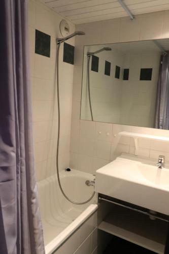 une salle de bain blanche avec une douche et un lavabo dans l'établissement Résidence Home Club - Studio confortable · Proche pistes et commerces MAE-0764, à Tignes