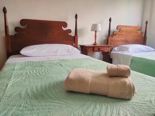 a bedroom with two beds with a towel on the bed at La Casa de la Abuela Boticaria in Redondela