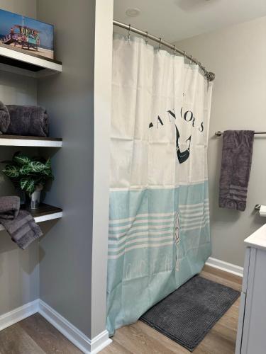 a shower curtain with the word amos on it in a bathroom at Holly Hill Haven in Edgewater
