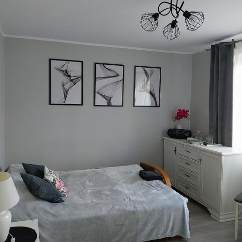 a bedroom with a bed and four pictures on the wall at Pokoje gościnne Słupy Olsztyn - parking in Olsztyn