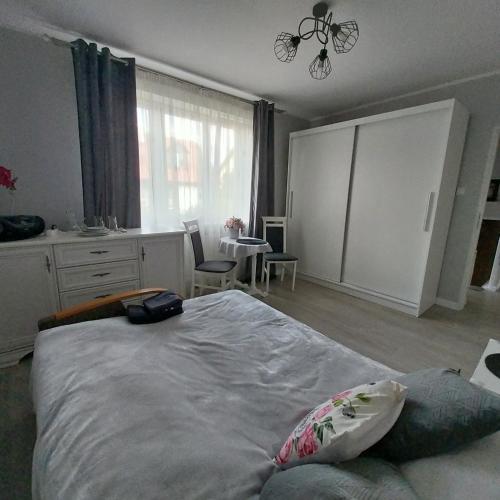 a bedroom with a large bed and a table and chairs at Pokoje gościnne Słupy Olsztyn - parking in Olsztyn
