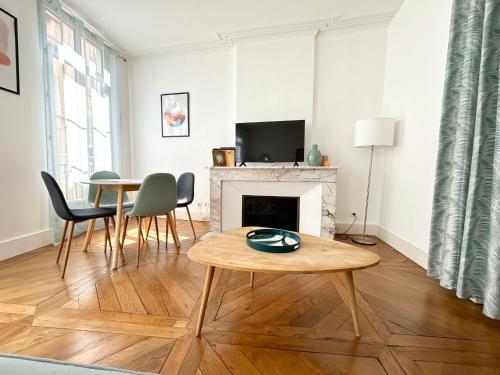 un salon avec une table et une cheminée dans l'établissement MARIA - Centre historique - Parking Privé, à Auch