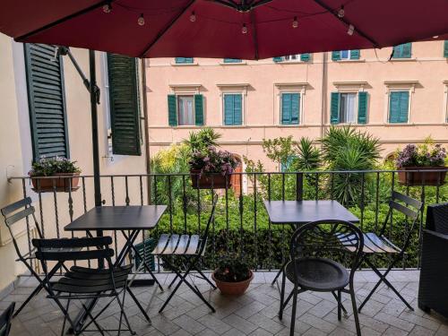 a patio with two tables and chairs and an umbrella at Hotel Soggiorno Athena in Pisa