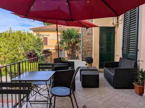 a patio with tables and chairs and an umbrella at Hotel Soggiorno Athena in Pisa