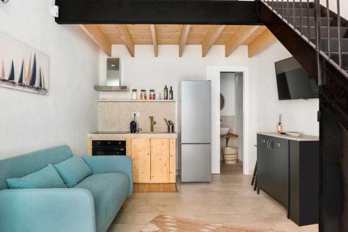 un salon avec un canapé bleu et une cuisine dans l'établissement U'Marranzanu Exclusive Relais, à Noto