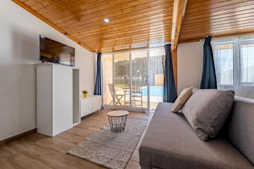 a living room with a couch and a large window at Wake up with the Sea Breeze- House with pool AP1 in Lavra