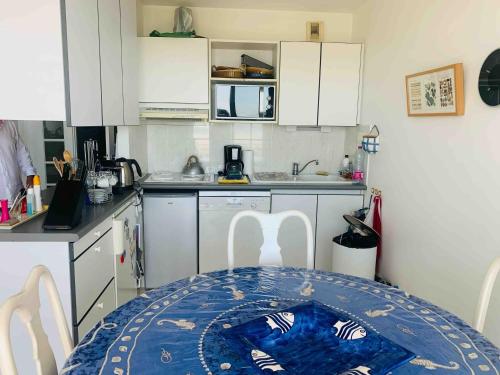 une petite cuisine avec une table et des chaises. dans l'établissement Superbe 3 pièces Villa Les Planches Vue Mer Deauville, à Tourgéville