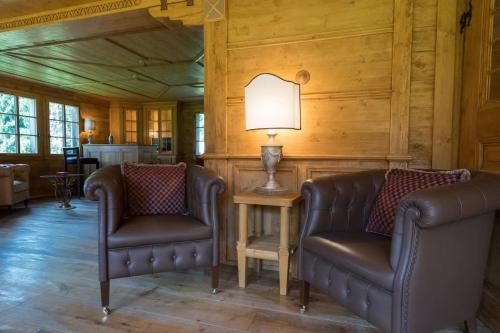 a living room with two leather chairs and a lamp at Gstaad - Great Luxurious Farmhouse in Kalberhöni