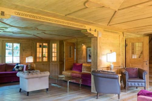 a living room filled with furniture and a wooden ceiling at Gstaad - Great Luxurious Farmhouse in Kalberhöni