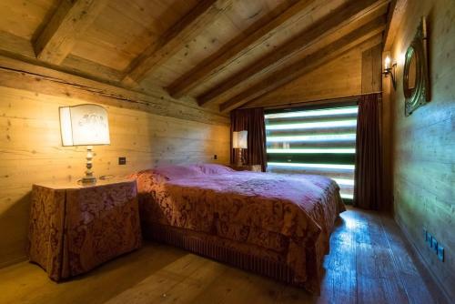 a bedroom with a bed in a wooden room at Gstaad - Great Luxurious Farmhouse in Kalberhöni