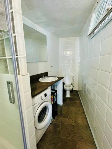 a small bathroom with a washing machine and a sink at Sea lover's nest in Los Realejos