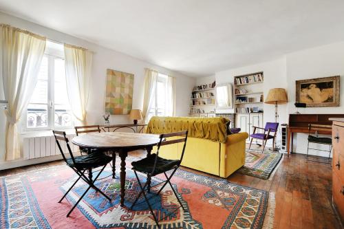 un salon avec une table et un canapé jaune dans l'établissement MONGE - PANTHEON Charming apartment, à Paris