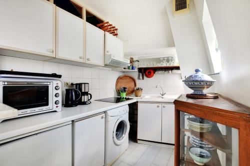 une cuisine avec des armoires blanches et un micro-ondes dans l'établissement MONGE - PANTHEON Charming apartment, à Paris