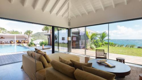a living room with a couch and a table at Spacious Villa with True Architectural Gem in Toiny