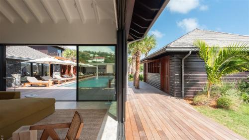 an external view of a house with a wooden deck at Spacious Villa with True Architectural Gem in Toiny